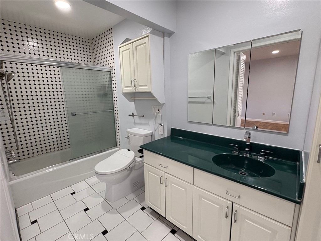 20730 Community Street Winnetka, CA 91306 - Photo 10 of 12 a bathroom with a granite countertop sink a toilet a mirror and shower