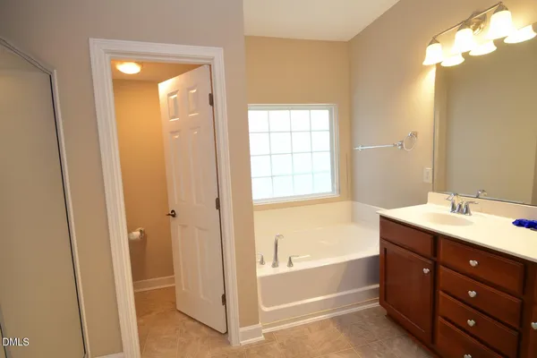a bathroom with a tub sink and mirror