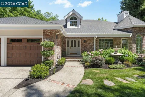 a front view of a house with a yard and outdoor seating