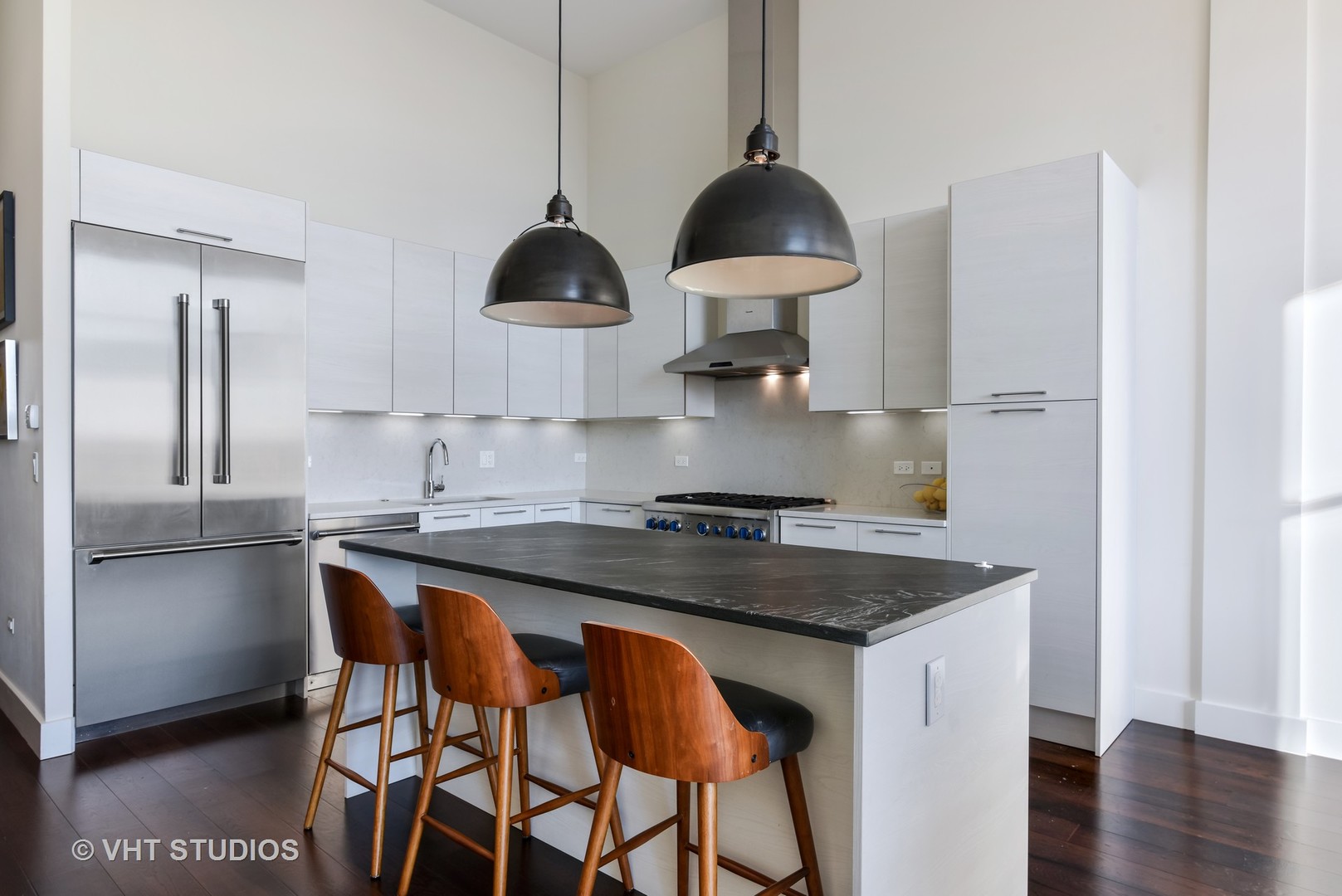 1132 West Adams Street, Unit PHE Chicago, IL 60607 - Photo 3 of 23 a kitchen with stainless steel appliances granite countertop a sink a stove and a refrigerator