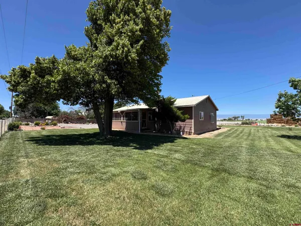 a yellow building in the middle of a yard
