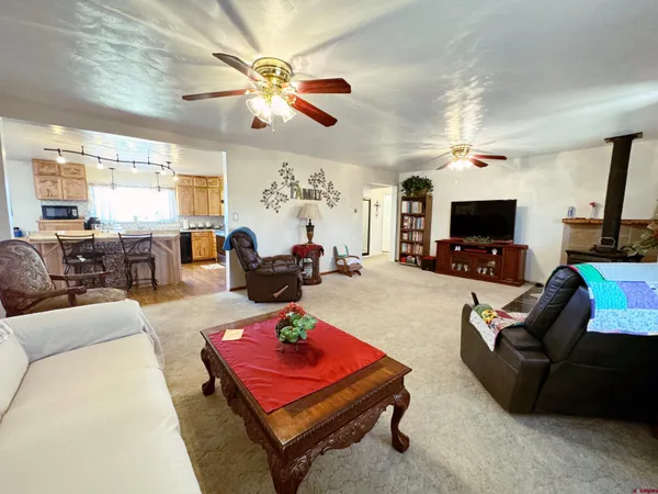 a living room with furniture a flat screen tv and a chandelier