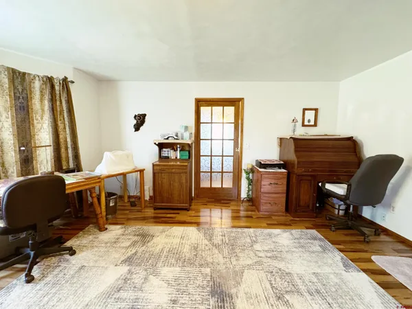 a living room with furniture a piano and a flat screen tv