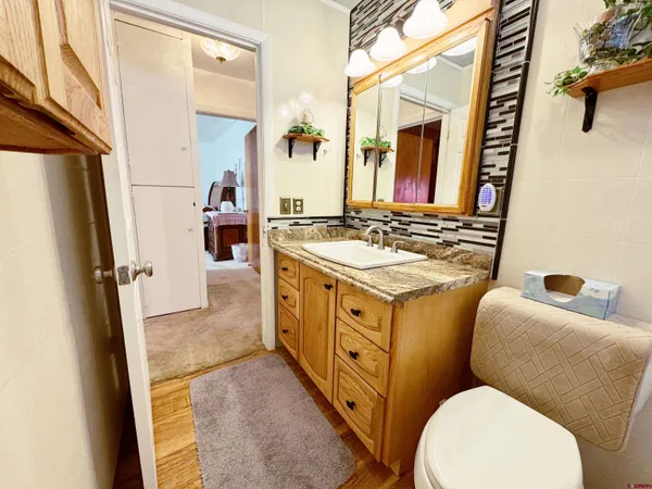 a bathroom with a sink mirror vanity and toilet
