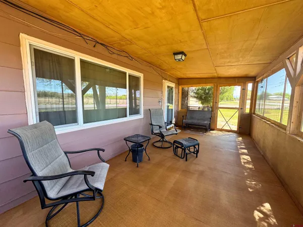 a living room with furniture and floor to ceiling windows