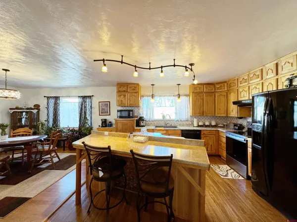 a kitchen with a table chairs stove and refrigerator