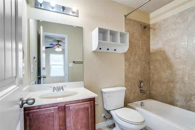 a bathroom with a granite countertop sink toilet a mirror and shower