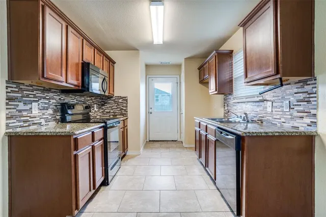 a kitchen with stainless steel appliances granite countertop a sink stove and cabinets