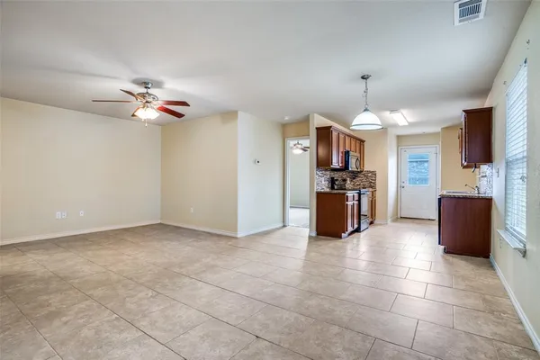 a kitchen with granite countertop a refrigerator and a chandelier