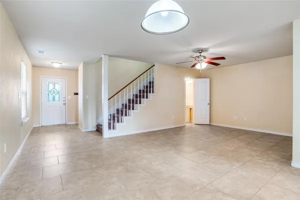 a view of an empty room with a chandelier fan