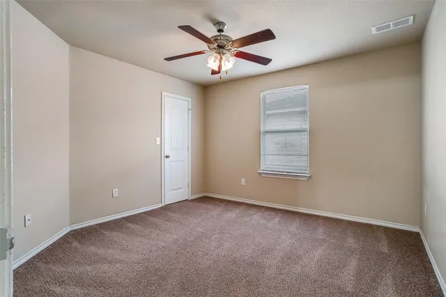 a view of an empty room with a ceiling fan