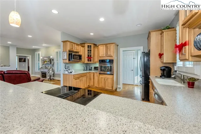 a kitchen with stainless steel appliances kitchen island granite countertop a refrigerator and a sink