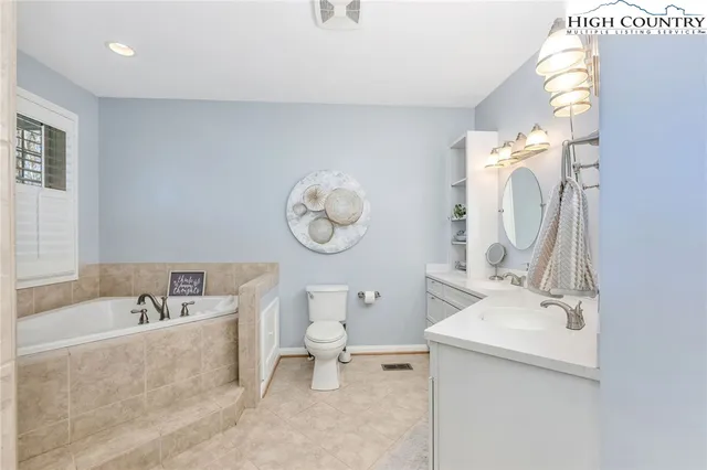 a bathroom with a sink mirror and toilet