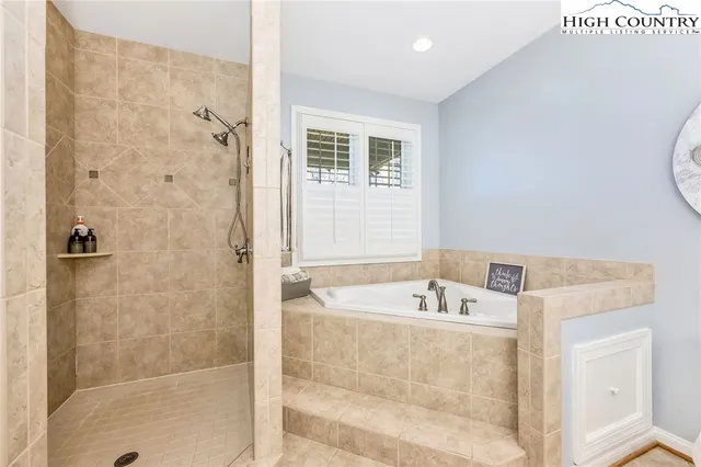 a bathroom with a tub a sink and a shower