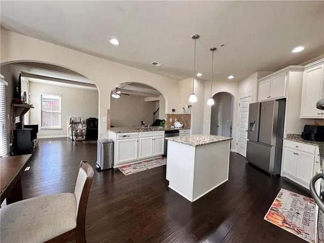 a kitchen with granite countertop white cabinets and white appliances
