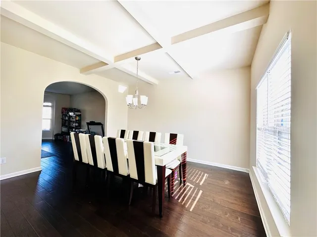 a view of a dining room with wooden floor windows and a chandelier