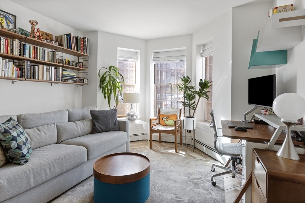 71 Dartmouth Street, Unit 1 Boston, MA 02116 - Photo 15 of 26 a living room with furniture a bookshelf and a potted plant