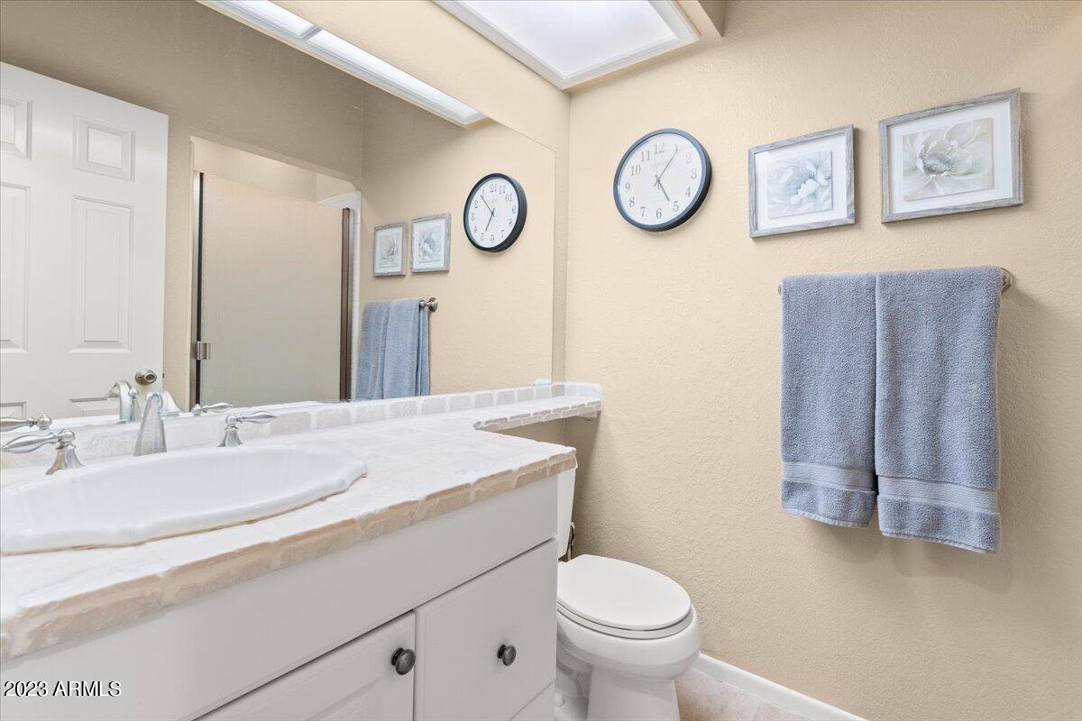10017 East Mountain View Road, Unit 2053 Scottsdale, AZ 85258 - Photo 26 of 31 a bathroom with a toilet sink and mirror