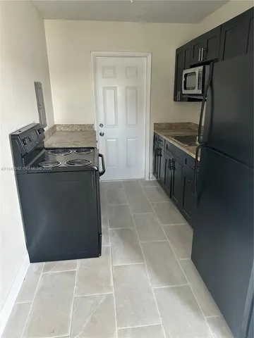 a kitchen with granite countertop a stove and a refrigerator