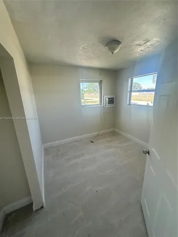 an empty room with windows and closet