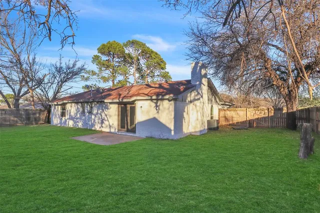 a view of a house with backyard and a tree