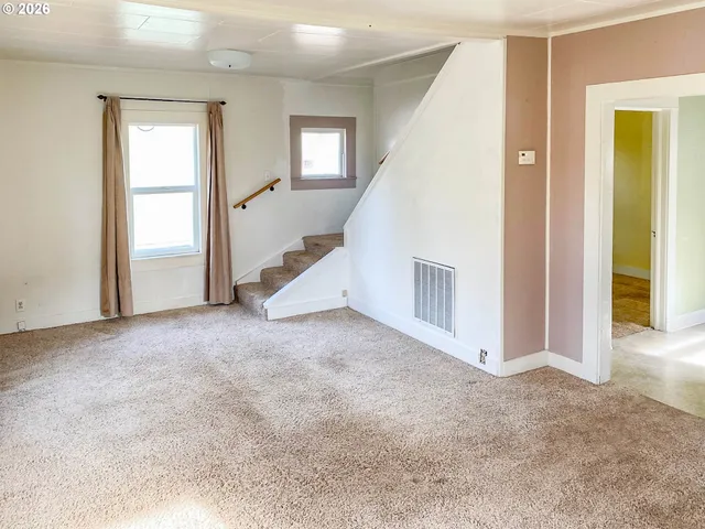 a view of an empty room with closet and windows
