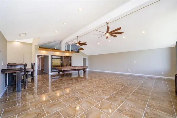 an empty room with fireplace cabinet and windows