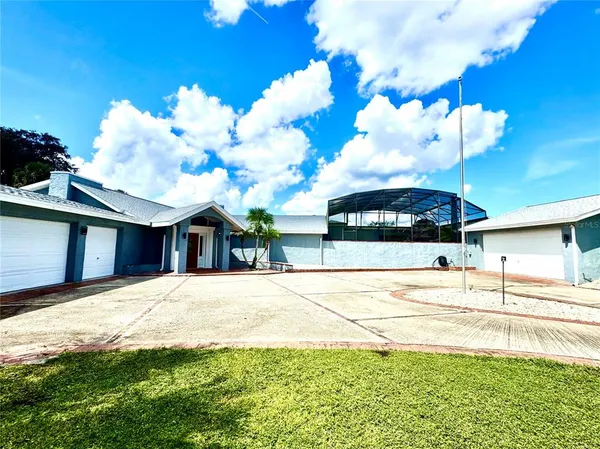 an aerial view of a house with a yard and lake view