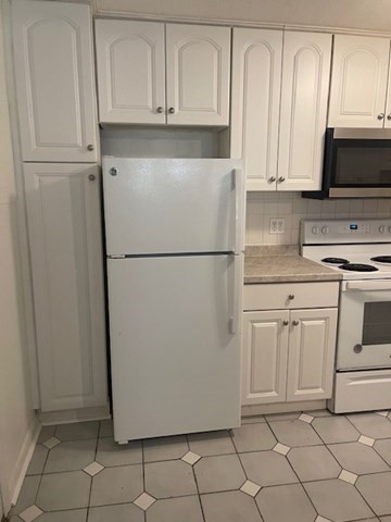 1323 Worcester Road, Unit 1E Framingham, MA 01701 - Photo 14 of 17 a white refrigerator freezer and a stove sitting inside of a kitchen