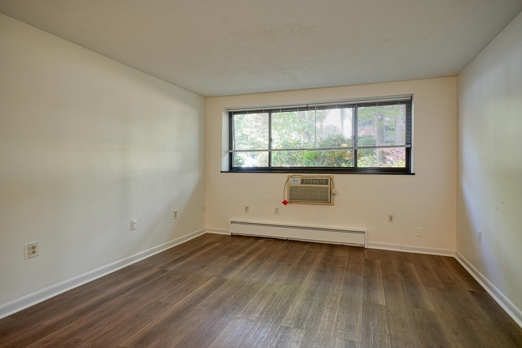 1323 Worcester Road, Unit 1E Framingham, MA 01701 - Photo 17 of 17 an empty room with wooden floor and windows