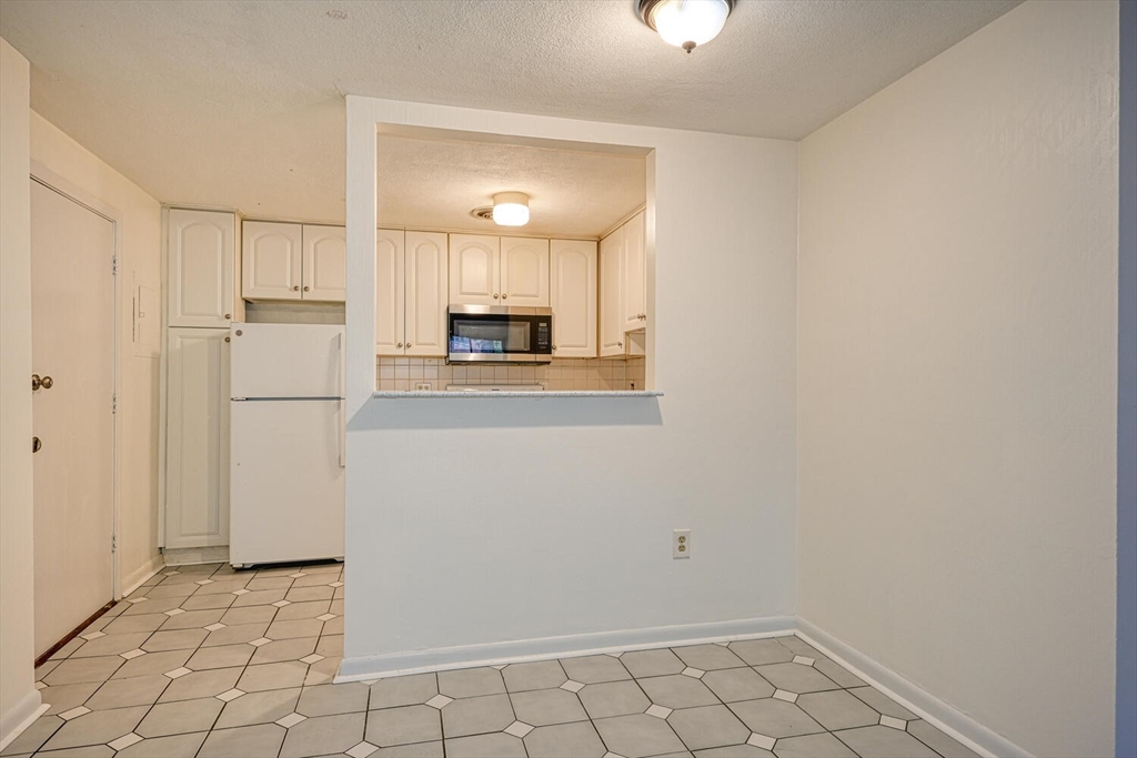 1323 Worcester Road, Unit 1E Framingham, MA 01701 - Photo 7 of 17 a view of a kitchen with a refrigerator a stove top oven and a refrigerator
