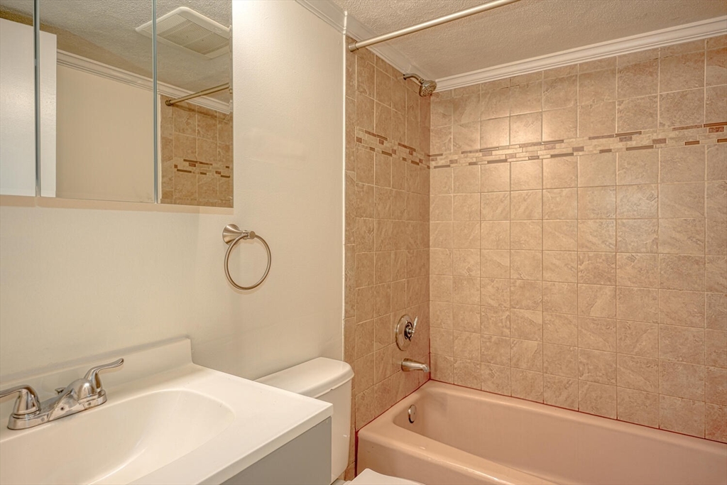 1323 Worcester Road, Unit 1E Framingham, MA 01701 - Photo 9 of 17 a bathroom with a sink a toilet and a bathtub