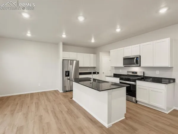 a kitchen with stainless steel appliances granite countertop a sink and refrigerator