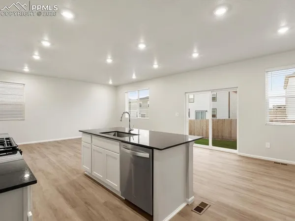 a kitchen with stainless steel appliances granite countertop a sink and a stove top oven