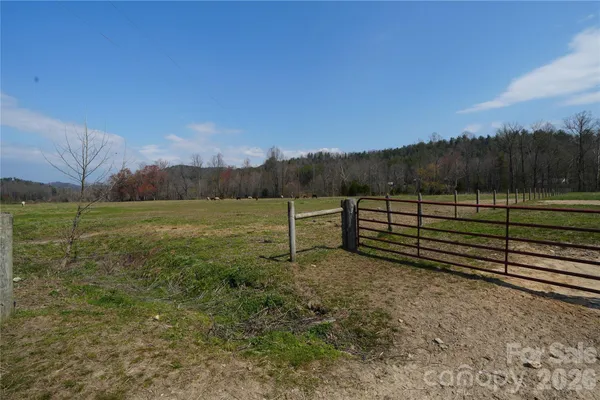a view of a yard with wooden fence