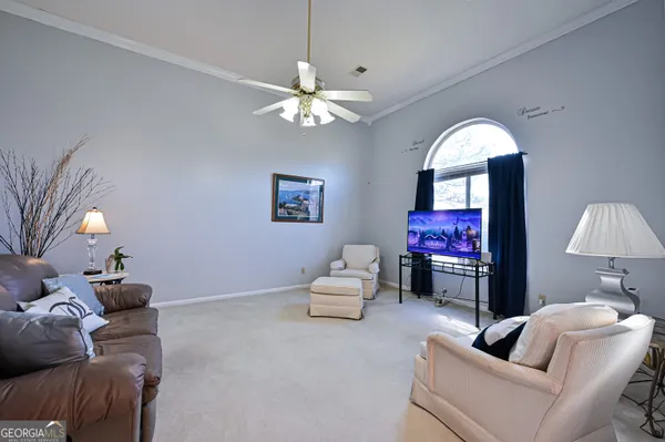 a living room with furniture a fireplace and a chandelier
