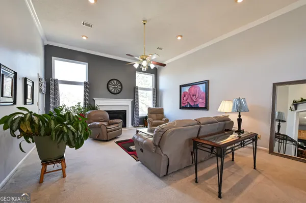 a living room with furniture a chandelier and a flat screen tv