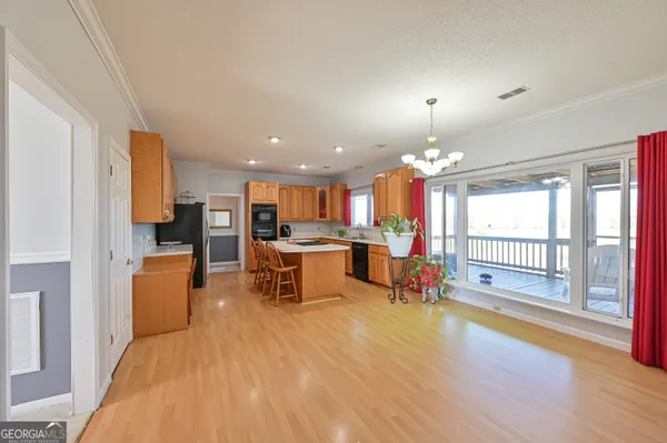 a kitchen with stainless steel appliances granite countertop a stove top oven a sink dishwasher and a refrigerator with wooden floor