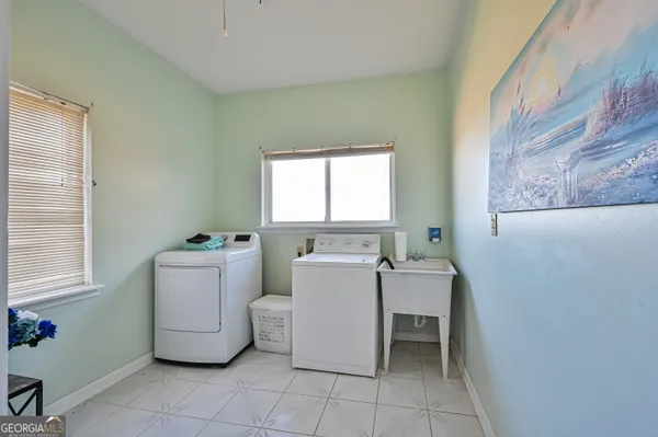 a bath room with a sink furniture and a chandelier