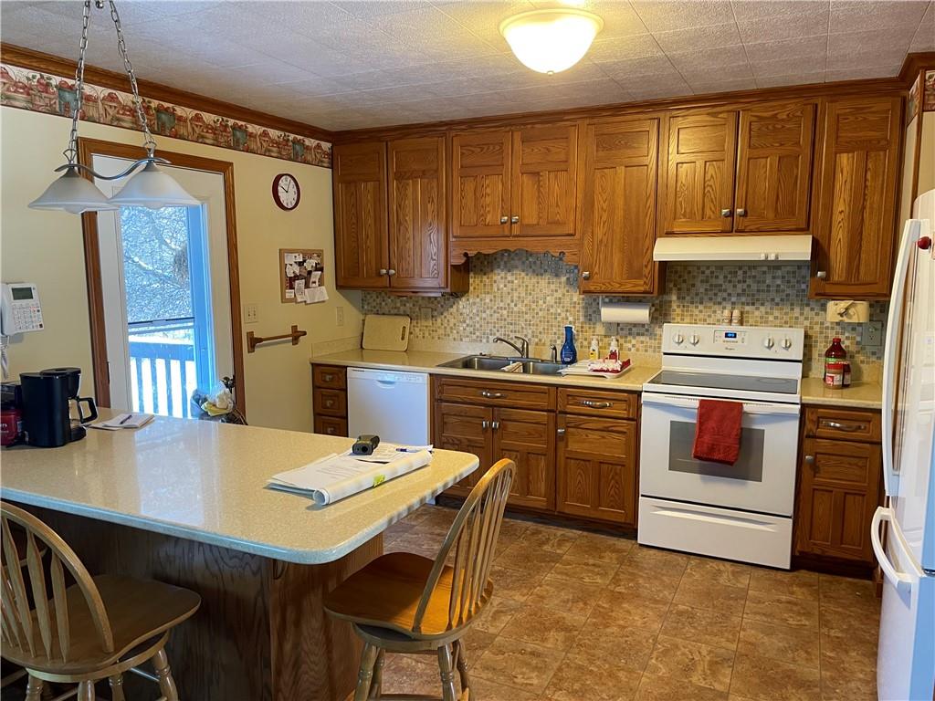 506 Lake Wilhelm Road Sandy Lake, PA 16145 - Photo 25 of 42 a kitchen with a table chairs stove and cabinets