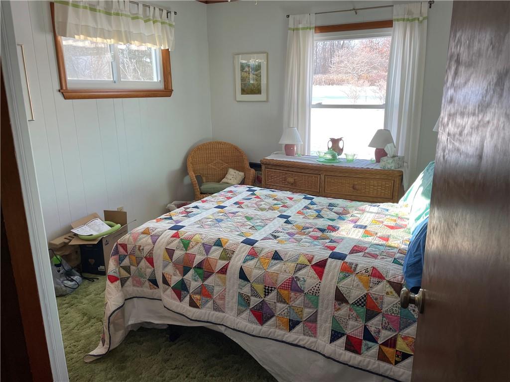 506 Lake Wilhelm Road Sandy Lake, PA 16145 - Photo 30 of 42 a bedroom with a bed that has a blanket on it and next to a window