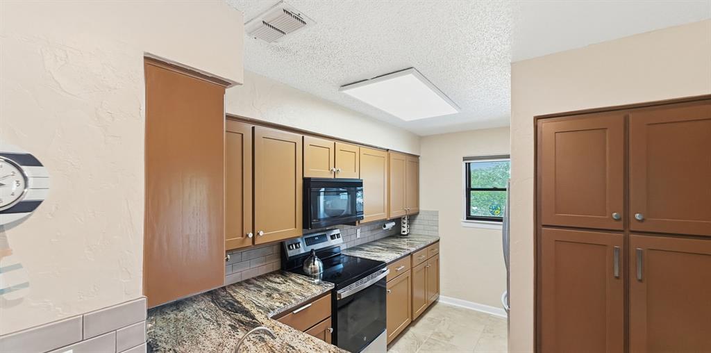 3037 Hells Gate Loop, Unit C208 Strawn, TX 76475 - Photo 11 of 24 a kitchen with a refrigerator stove and microwave