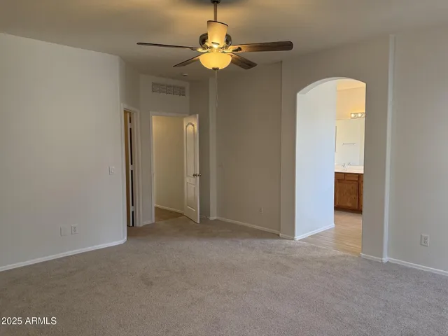 a view of an empty room with a chandelier fan