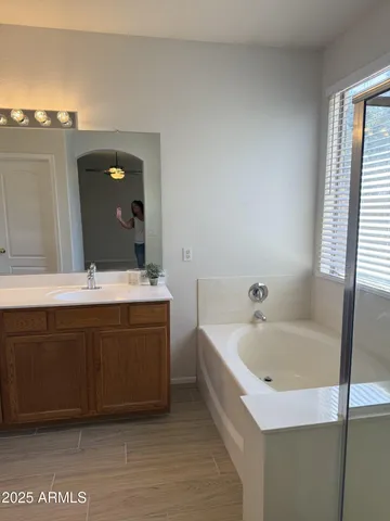 a bathroom with a bathtub sink and mirror