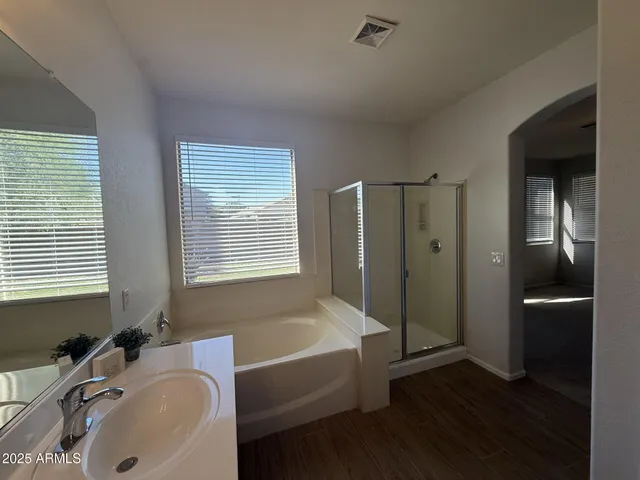a bathroom with a tub sink and mirror