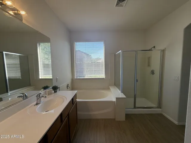 a bathroom with a tub sink and mirror