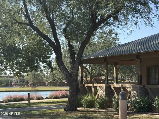 a front view of a house with garden and trees