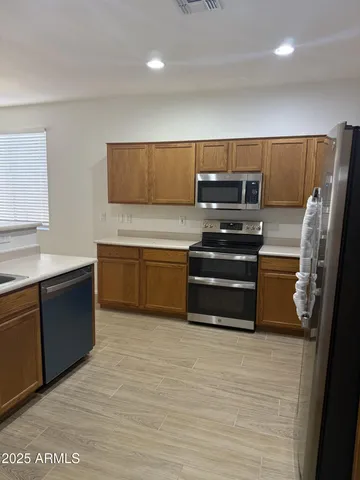 a kitchen with stainless steel appliances wooden cabinets and a sink