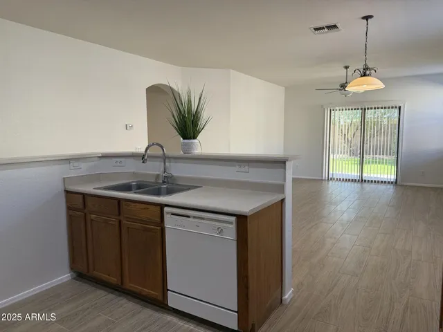 a kitchen with a sink and wooden floor