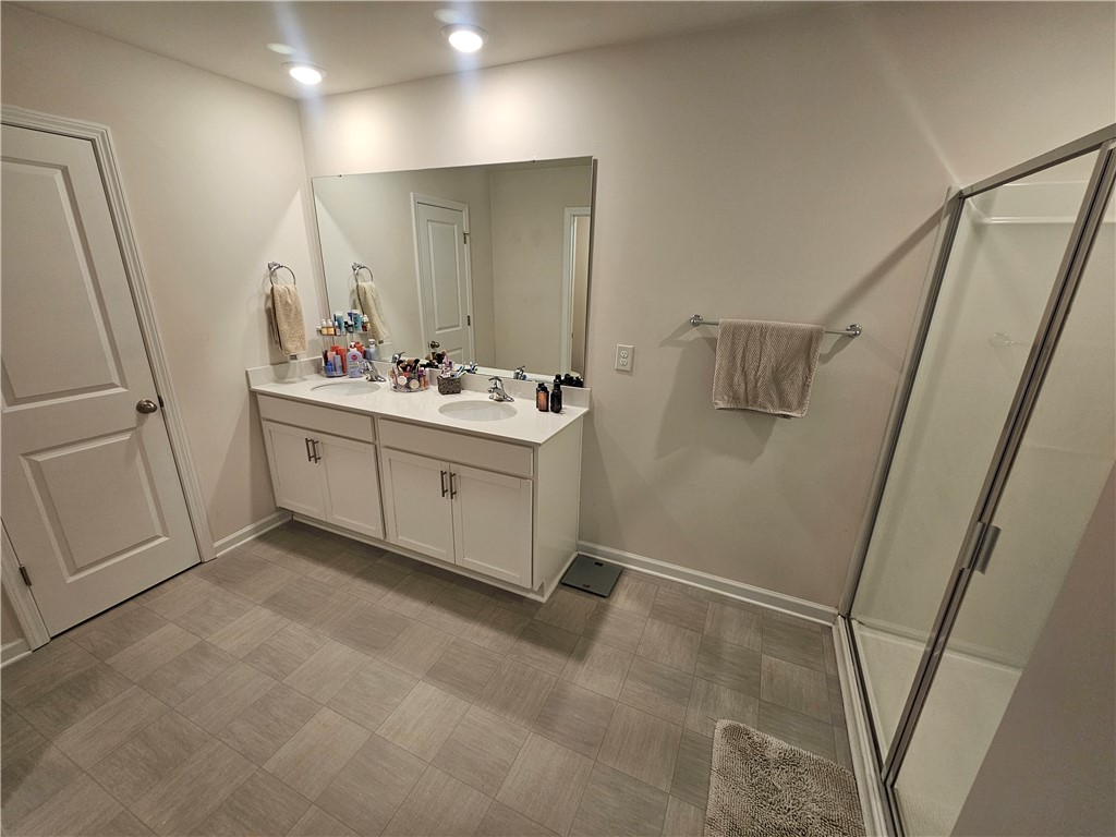 902 Ashwood Lane Easley, SC 29640 - Photo 24 of 39 Double vanity sinks and a glass-enclosed shower create a practical primary bathroom.